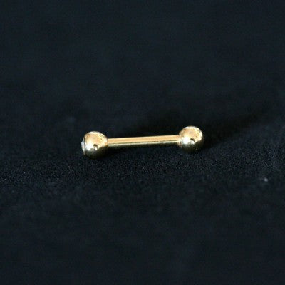 piercing de aço cirúrgico banhado a ouro com haste reta e esferas nas extremidades sobre fundo preto. há uma pedra de cristal em uma das esferas.