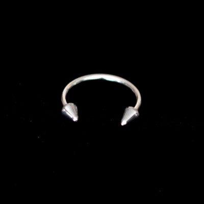 piercing barbell da tal da realeza em um fundo preto aveludado. a peça é prateada, tem formato de ferradura e possui spikes nas extremidades.