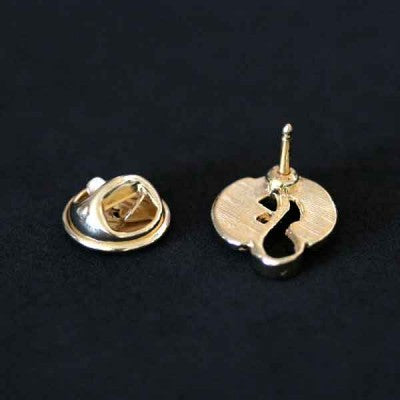 Broche Fonoaudiologia folheado a ouro em um fundo branco, visto por trás. É possível ver o alfinete e o encaixe do bottom.