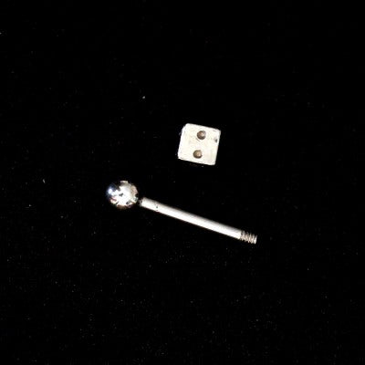 Piercing Tragus em aço cirúrgico da Tal da Realeza desmontado em um fundo preto aveludado. A peça tem formato de dado na ponta.