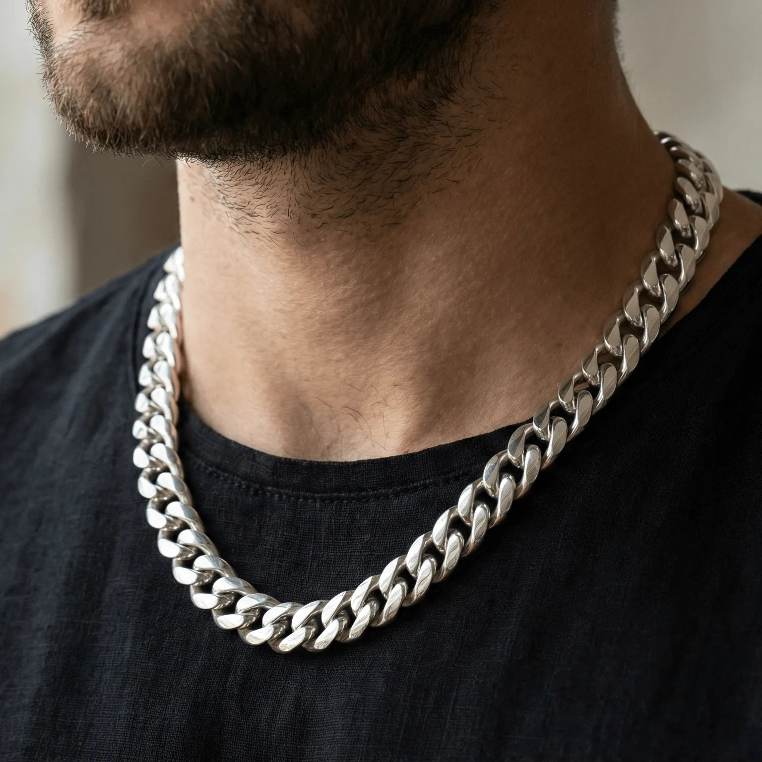 Homem vestindo camiseta usando uma corrente de prata masculina de espessura grossa. Joia em prata para estilo casual moderno.