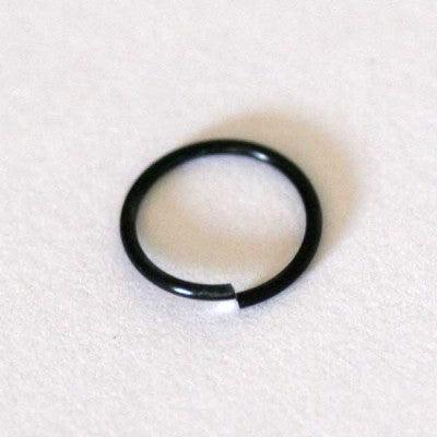 Piercing Nostril em aço cirúrgico da Tal da Realeza em um fundo branco aveludado. A peça é preta e tem formato de argola.