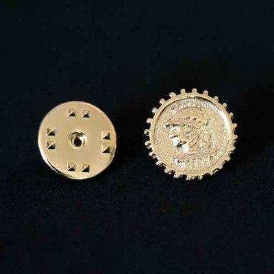 Broche Engenharia Civil folheado a ouro em um fundo preto. A peça é composta pela imagem de Minerva no centro de uma engrenagem.