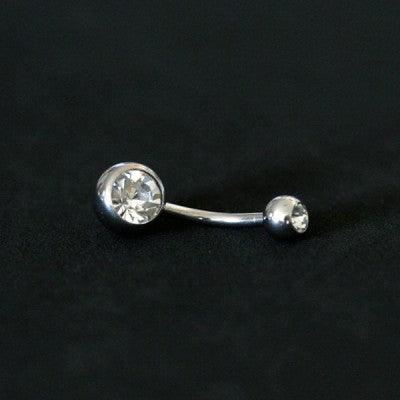 piercing de umbigo da tal da realeza um fundo preto aveludado. a peça é feita de aço cirúrgico e conta com pedras de zircônia nas extremidades.