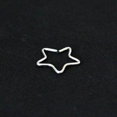 Piercing Tragus em aço cirúrgico da Tal da Realeza em um fundo preto aveludado. A peça tem formato de uma estrela.