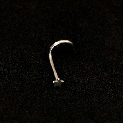 Piercing Nostril em aço cirúrgico da Tal da Realeza em um fundo preto aveludado. A peça tem formato de estrela na ponta.
