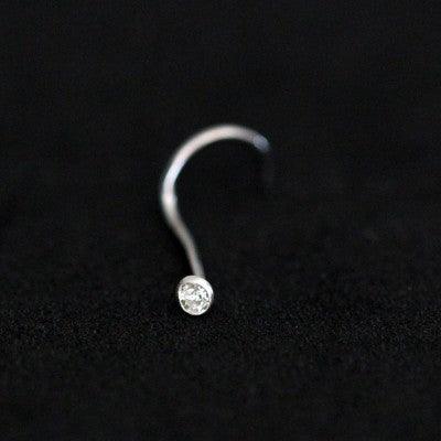 piercing nostril em aço cirúrgico da tal da realeza em um fundo preto aveludado. a peça tem uma pedra cravada na ponta.