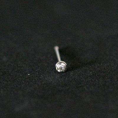Piercing Nostril em aço cirúrgico da Tal da Realeza em um fundo preto aveludado. A peça tem formato uma pedra de cristal na ponta.