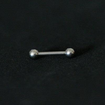 Piercing de aço cirúrgico com formato de barra reta com esferas nas extremidades sobre fundo preto.