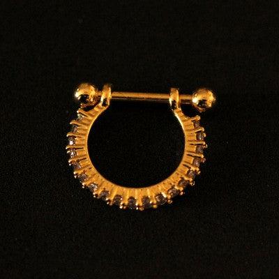 Piercing Conch folheado a ouro 18k da Tal da Realeza visto por cima em um fundo preto aveludado.