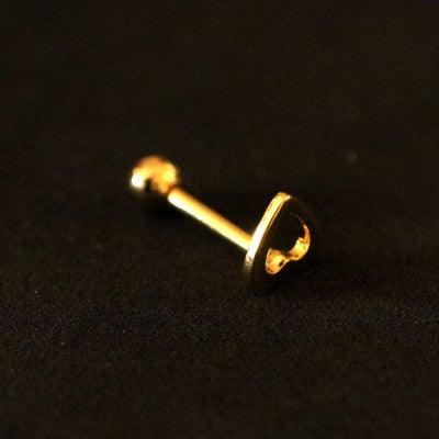 Piercing Tragus folheado a ouro da Tal da Realeza visto pela diagonal em um fundo preto aveluadado. A peça tem um coração vazado em uma das pontas.