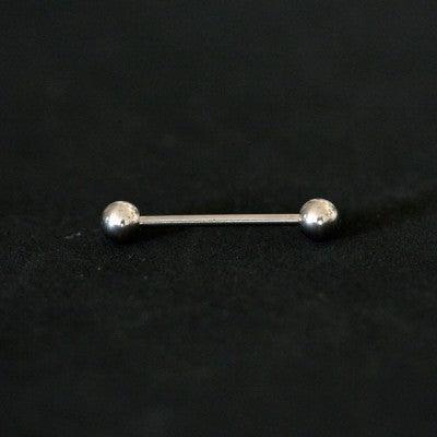 Piercing de aço cirúrgico com formato de barra reta com esferas nas extremidades sobre fundo preto.