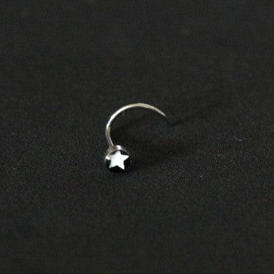 Piercing Nostril em aço cirúrgico da Tal da Realeza em um fundo preto aveludado. A peça tem uma estrela na ponta.
