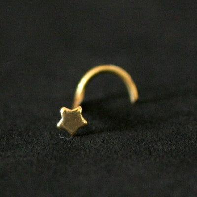 Piercing Nostril folheado a ouro da Tal da Realeza em um fundo preto aveludado. A peça tem formato de estrela na ponta.