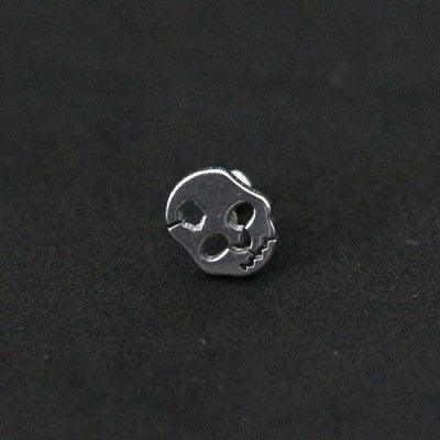 Piercing Tragus em aço cirúrgico da Tal da Realeza em um fundo preto aveludado. A peça tem formato de alien em uma das extremidades.