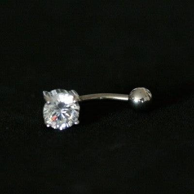 Piercing de umbigo da Tal da Realeza visto de frente em um fundo preto aveludado. A peça é feita de aço cirúrgico e conta com uma pedra de zircônia.